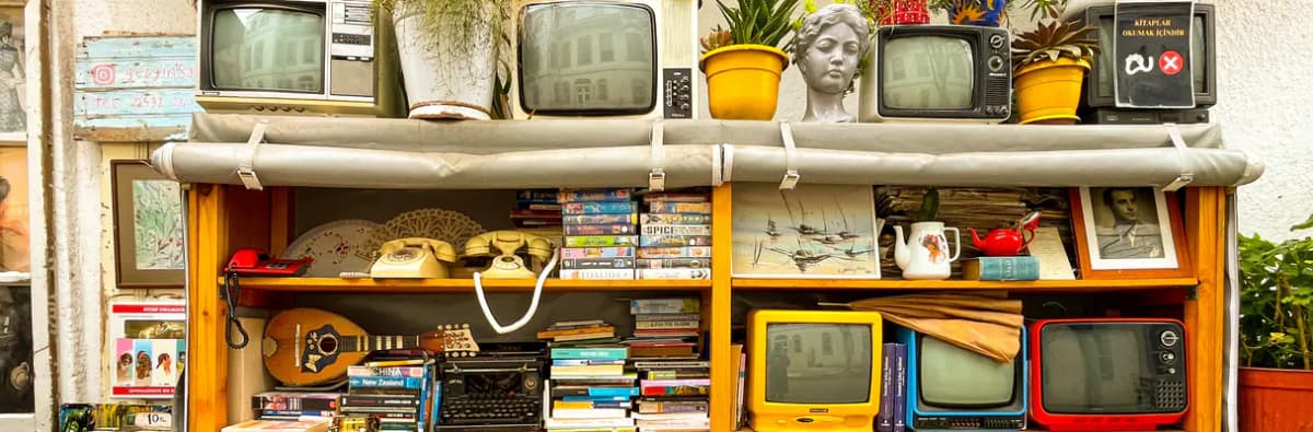 Étagère de livres anciens, téléphones à cadran et téléviseurs vintage