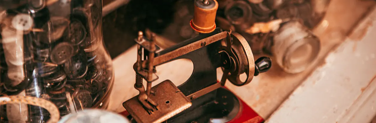 Machine à coudre miniature ancienne et bocaux de boutons
