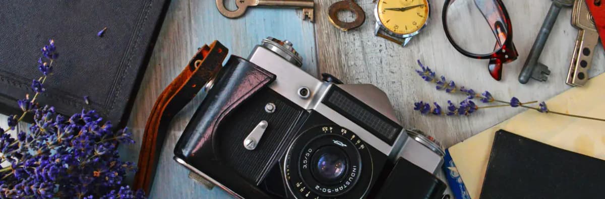 Appareil photo argentique, montre, lunettes et clés anciennes sur bois patiné